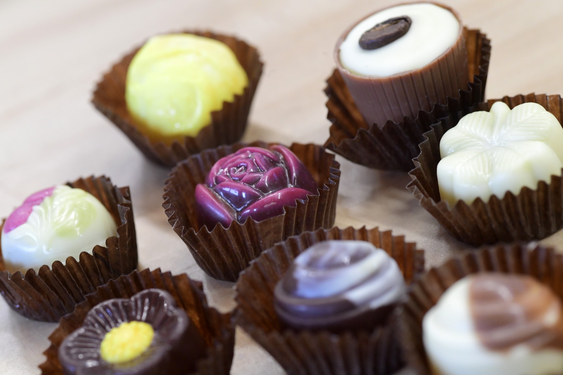 Acht verschiedene Pralinen in einer braunen Pralinenhülle der Marke Goethe Chocolaterie
